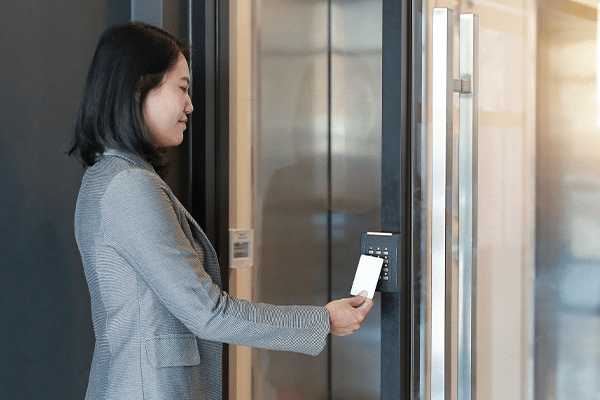 Door access control – young officer woman holding a key card to lock and unlock door for access entry_ Door access control young officer woman holding a key card to lock and unlock door for access entry